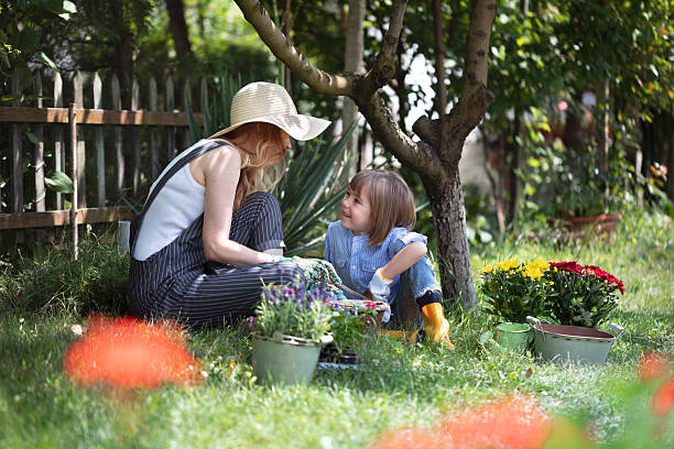Mother and child gardening together planting flowers